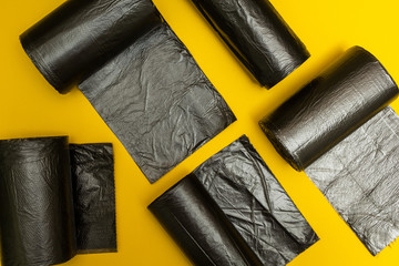 New black garbage bags on a yellow background.