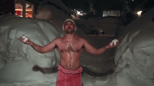 Man after sauna, in a towel barefoot on the snow. healthy lifestyle
