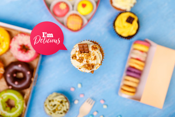 Cupcake with nuts cream, Donuts and Macaroons. Sweet dessert. Cakes with buttercream. Almond macaron cookies. Delivery box.