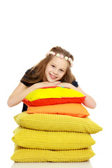 Beautiful girl among the soft pillows.