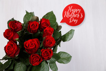 Red roses on white wood vintage background. Happy Mothers day design. Fresh natural flowers. Painted wooden planks.