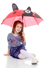 Little girl hiding under an umbrella.