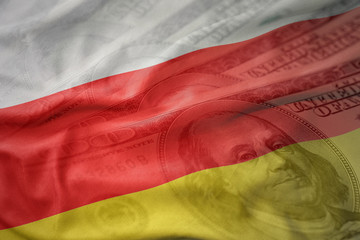 colorful waving national flag of south ossetia on a american dollar money background. finance concept
