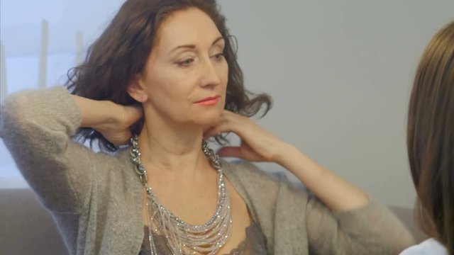 Woman appraise necklaces, chains, bracelets in jewelry store