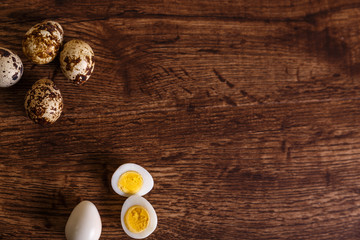 Quail eggs. Raw and boiled sliced food. Natural organic eco eggs. Wooden rustic background.