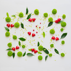 Hearts with pattern from petals of chrysanthemum flowers, ficus leaves and ripe rowan on white background. Overhead view. Flat lay.