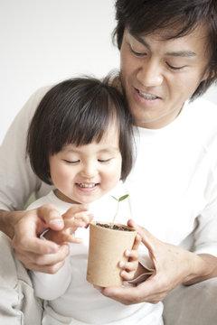 Father and son holding potted plant