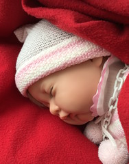 Baby doll with cap sleeping and wrapped in blanket. Newborn child puppet looks like real infant, best toy and gift for little girls. Image for baby magazine, family blog, baby shower invitation card - 140721140