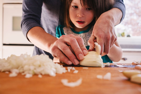 Mother Teaching Her Daughter To Chop Onions