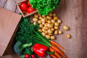 Vegetables. Potatoes, carrot and red pepper. Lettuce salad, garlic and brocoli. Red radish and tomatoes. Shopping bag.