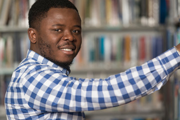 Handsome Young College Student In A Library