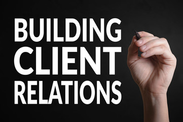 Hand writing the text: Building client relations