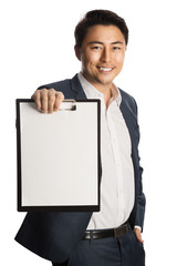 Attractive businessman in a blue suit and white shirt, holding a clipboard and a pen. Standing against a white background with a big toothy smile.