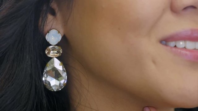 Young Woman Puts On Beautiful Dimond Earring And Smiles