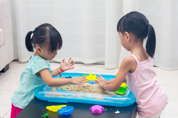 Asian Chinese little girls playing kinetic sand at home