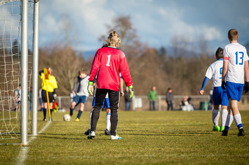 Obraz premium Young soccer goalie and defenders getting ready for a corner kick