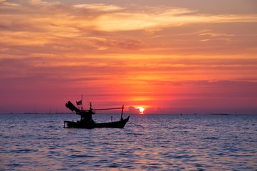 Silhouette of fisherman boat with during sunset in Thailand