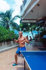 Man serving the ball. Adult man serving the ball playing ping pong. Vertical outdoors shot.