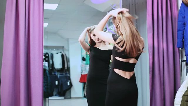 Young woman checking her appearance in front of the mirror