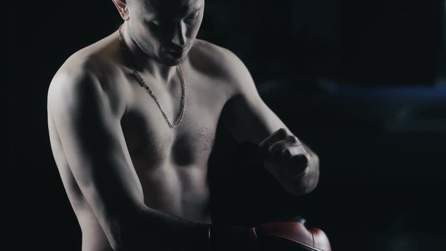 Athlete kickboxer dresses boxing gloves