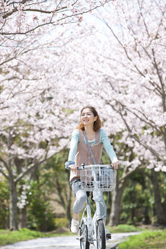 Young woman riding a bicycle near cherry trees