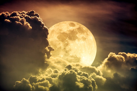 Nighttime sky with clouds and bright full moon with shiny.  Sepia tone.