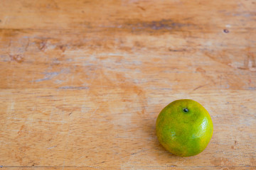 Green orange fruit on a wood table