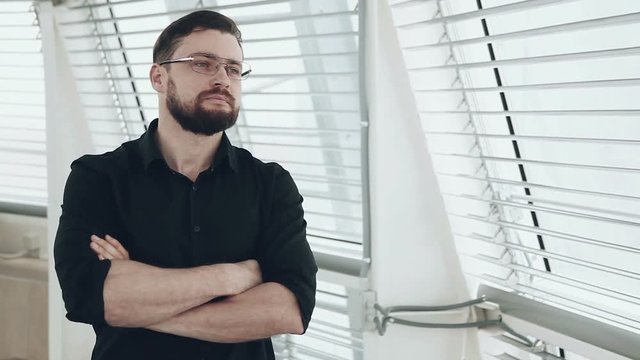 Young businessman looking out of window