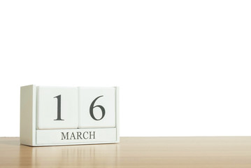 Closeup surface white wooden calendar with black 16 march word on blurred brown wood desk isolated on white background with copy space , selective focus at the calendar