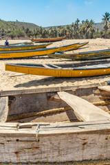 Wide view of group of fishing boats parked alone in seashore with people in the background, Visakhapatnam, Andhra Pradesh, March 05 2017