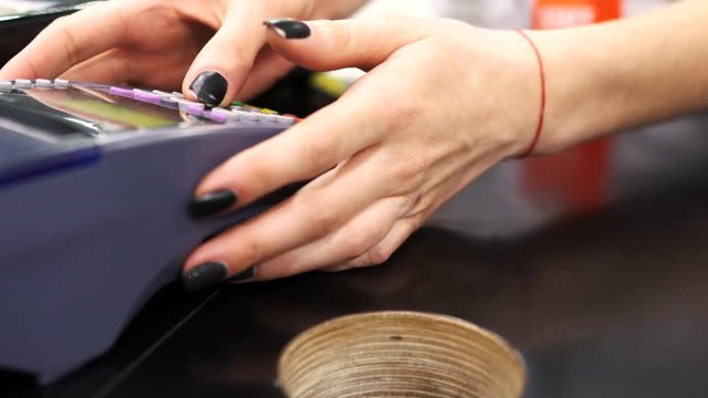 Shop assistant inserting a credit card into a pos and tearing off a receipt