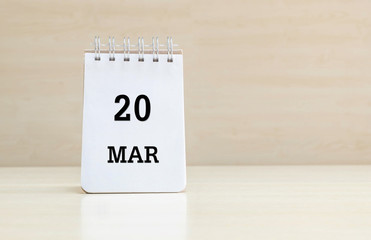 Closeup surface note book with black 20 mar word in page on blurred brown wood desk and wood wall textured background with copy space under window light