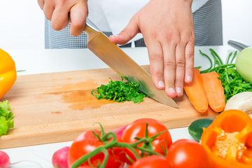 cutting with a sharp knife parsley close up on a wooden board