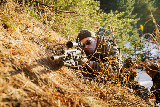 Army sniper during the military operation in the winter forest.