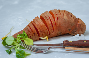 Baked sweet potato on a light background.