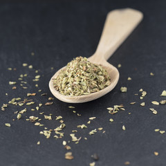 Oregano on wooden spoon and slate background