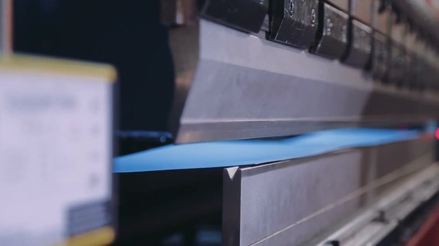 Pressing sheet metal on a machine tool factory. Worker puts the steel sheet in the installation. High precision manufacture of steel parts. Closeup