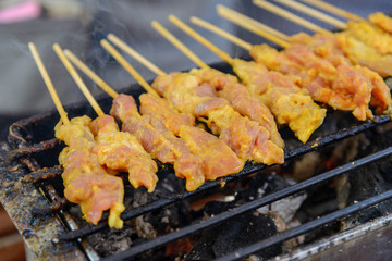 Grilling Pork satay on charcoal stove, Street food. Bangkok. Thailand