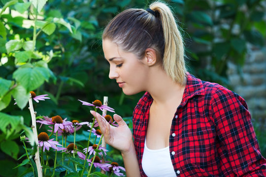 Girl smelling flowers in her garden
