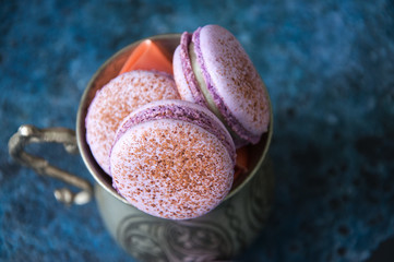 Macaron cookies in a vintage jar on a blue background. Overhead view.