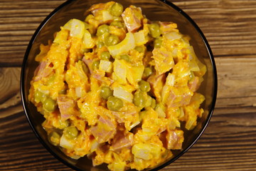 Mayonnaise salad with sausage, green pea, carrot and onion