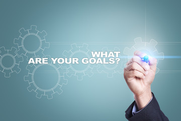 Businessman drawing on virtual screen. what are your goals concept.