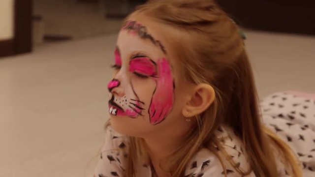 little girl with faceart on birthday party in process close up