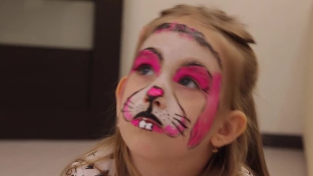 little girl with faceart on birthday party in process close up
