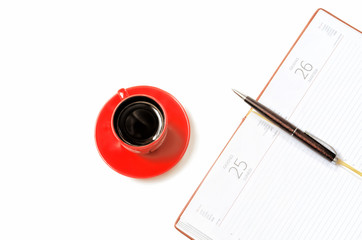 Open notebook and cup of coffee on a white background from above.