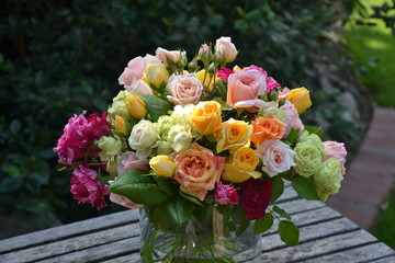 Romantischer und farbenfroher Rosenstrauß auf dem Gartentisch