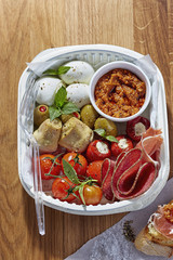 Antipasti lunch office - mozarella, artichoke, salami, red pesto, cherry tomatoes and feta stuffed peppers