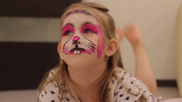 little girl with faceart on birthday party in process close up