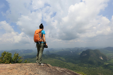Fototapeta na wymiar successful woman hiker hiking on mountain peak