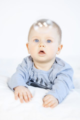 Fototapeta premium beautiful baby boy lying in bed on white background